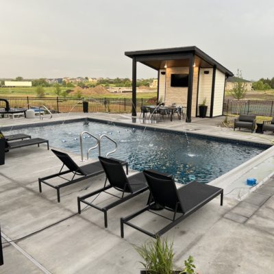 A beautiful backyard pool in Iowa complete with water jets and outside dining area.